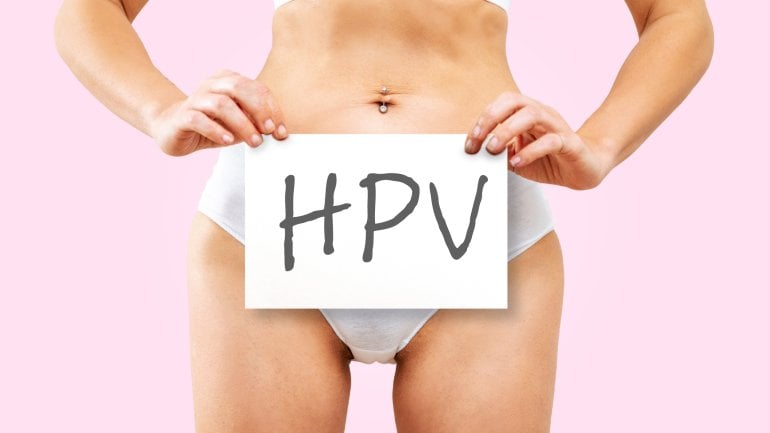 Eine Frau in Unterwäsche hält sich ein Schild mit der Aufschrift "HPV" vor den Unterleib