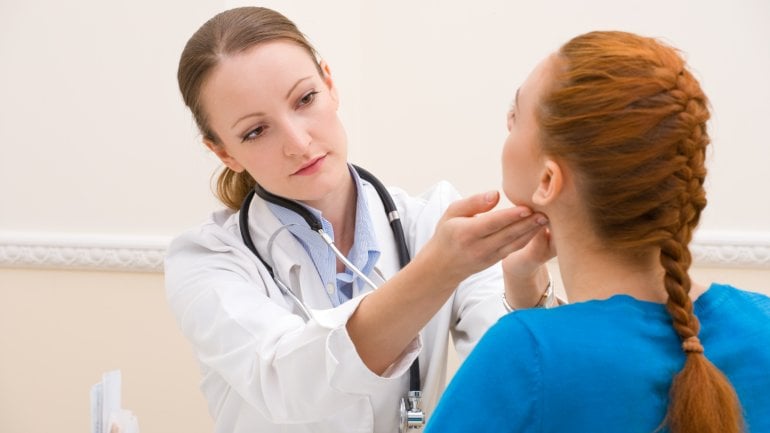 Das Bild zeigt eine Ärztin, die den Hals einer Patientin abtastet. 