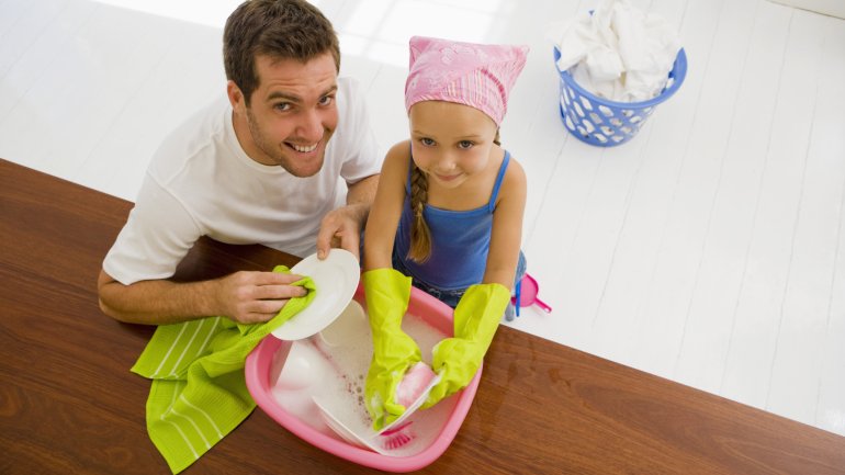 Vater und Tochter spülen Geschirr ab