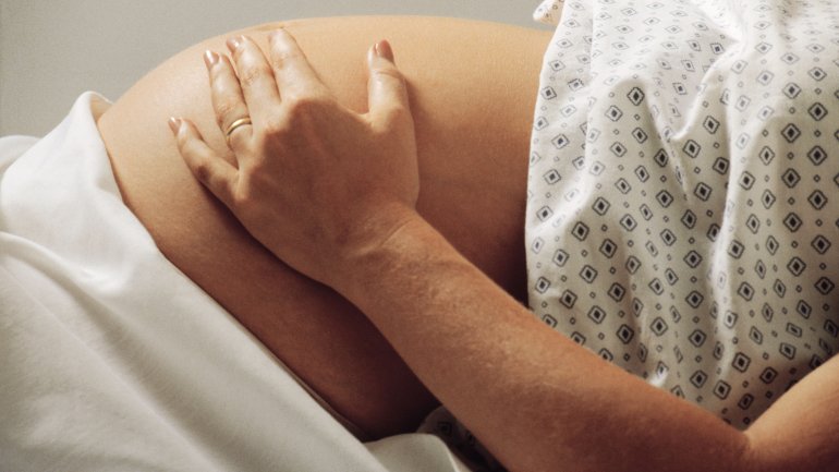 Schwangere legt eine Hand auf den Bauch