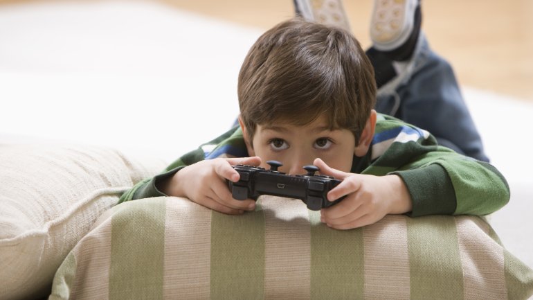 Ein Junge liegt auf dem Boden und spielt ein Videospiel