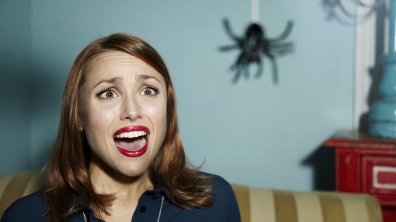 Frau mit Atachnophobie sieht Spinne