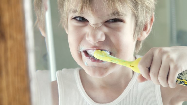 Ein Junge putzt sich die Zähne.