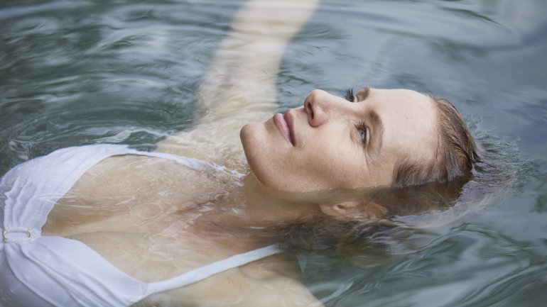 Frau schwimmt schwerelos im Salzwasser (Floating) und entspannt.