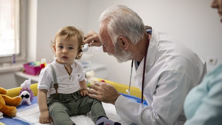 Kleiner Junge wird beim Ohrenarzt auf eine Mittelohrentzündug untersucht.