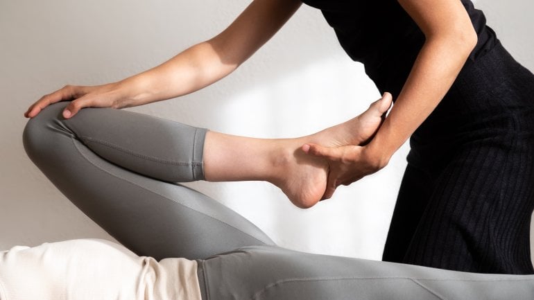 Physiotherapeut dehnt Bein bei Leistenzerrung