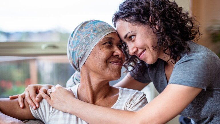 Eine Frau umarmt ihre an Krebs erkrankte Mutter