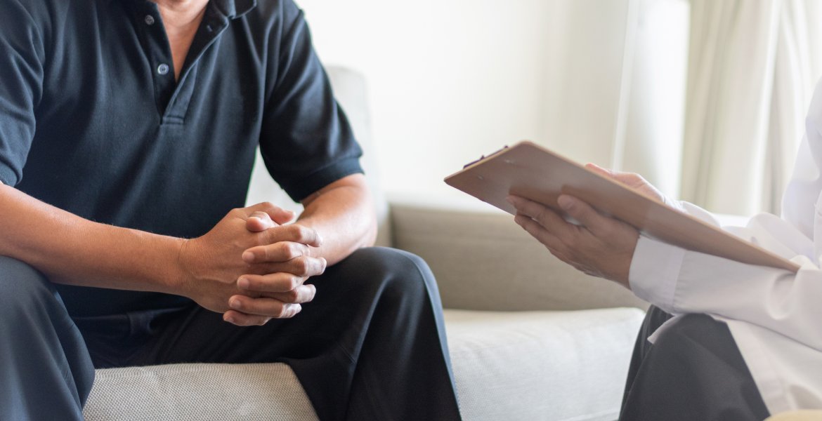 Prostatakrebs-Symptome: Mann im Gespräch mit einem Arzt
