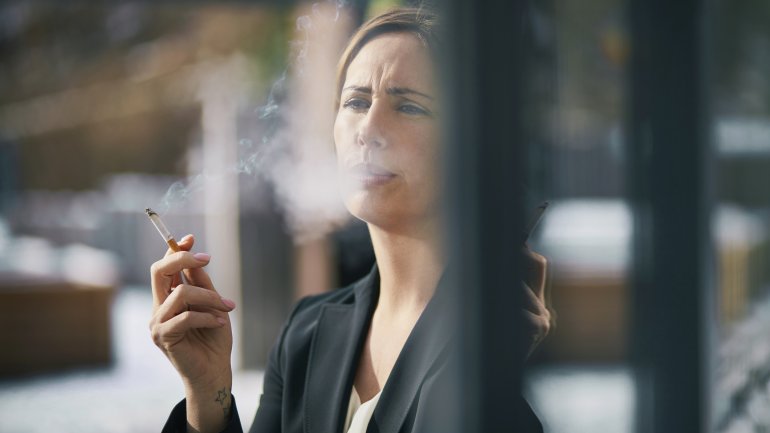 Abhängigkeit: Frau raucht eine Zigarette.