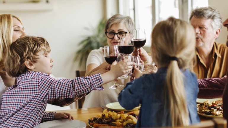 Eine Familie stößt mit Rotwein an.