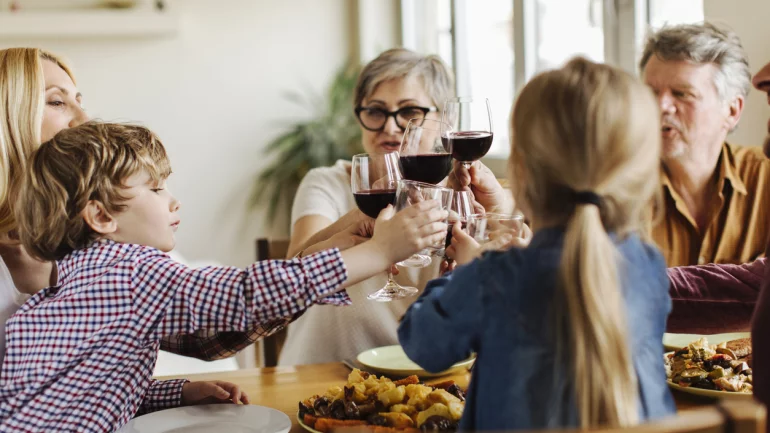 Eine Familie stößt mit Rotwein an.