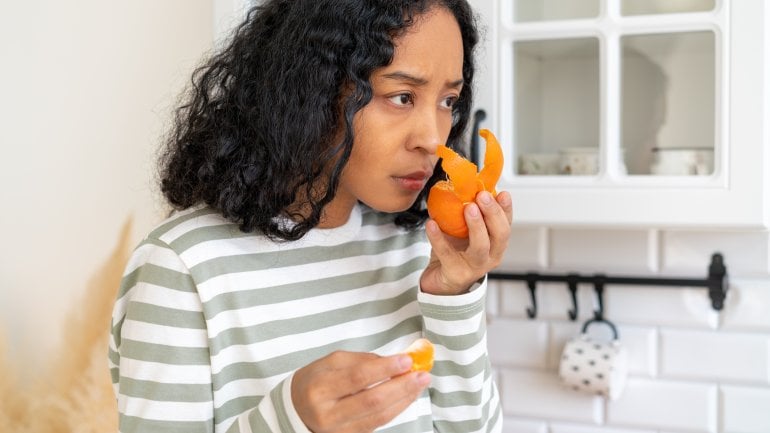 Anosmie: Frau riecht an einer Orangenschale