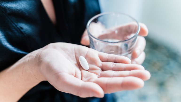 Eine Frau hält Antibiotika Tabletten in der Hand