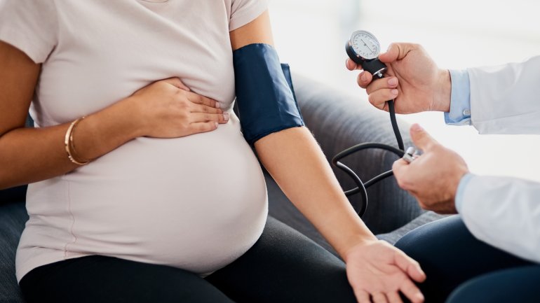 Bei einer schwangeren Frau misst ein Arzt Blutdruck