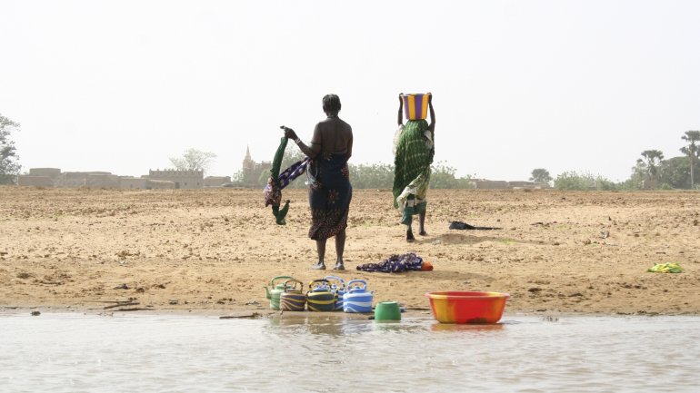 Das Bild zeigt zwei afrikanische Frauen am Wasser.