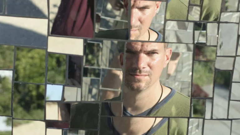 Das Gesicht eines Mannes in verschiedenen Spiegelstücken.