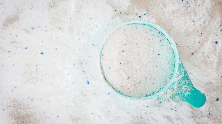 Das Bild zeigt Waschpulver mit einer blauen Dosierhilfe. 