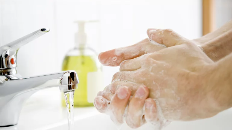 Jemand wäscht sich die Hände mit Wasser und Seife.