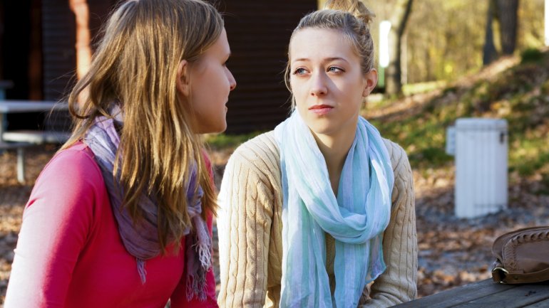 Das Bild zeigt zwei junge Frauen, die sich unterhalten.