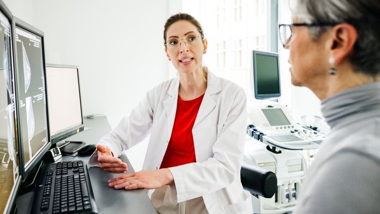 Ärztin klärt eine Frau über Fibrose auf.