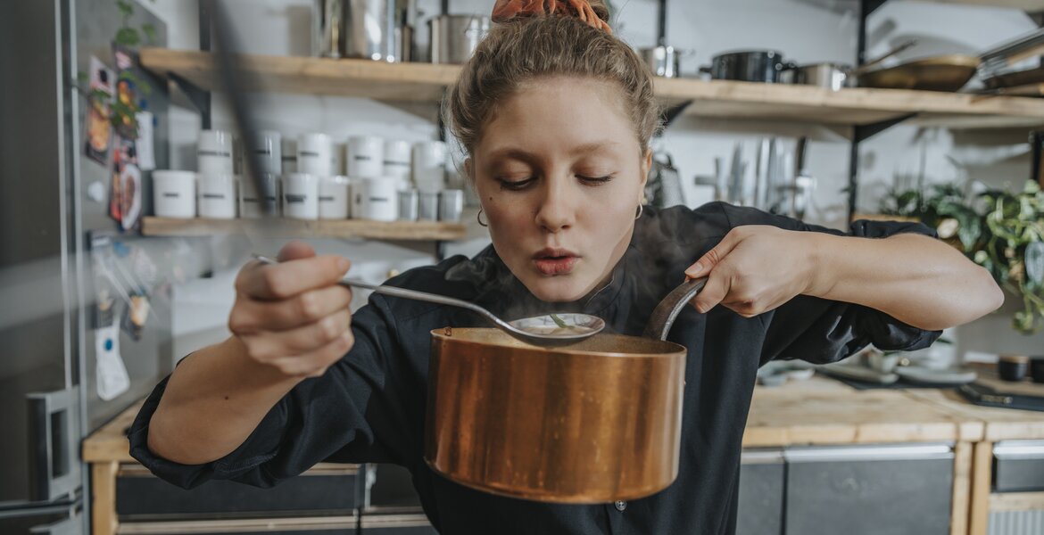 Divertikulitis Ernährung: Eine junge Frau isst Suppe aus einem Topf