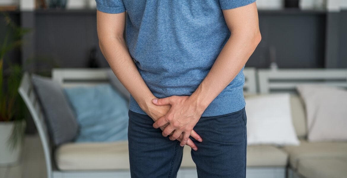 Penisbruch: Man sieht den Unterkörper eines Mannes der sich in den Schritt fasst