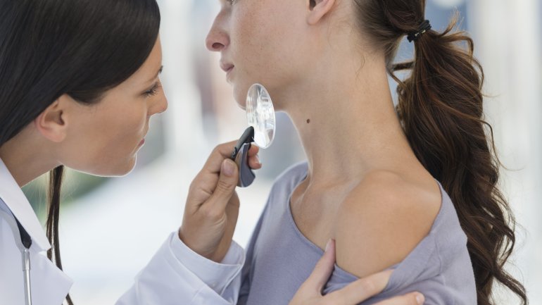 Eine Hautärztin (Dermatologin) untersucht die Haut einer Patientin.