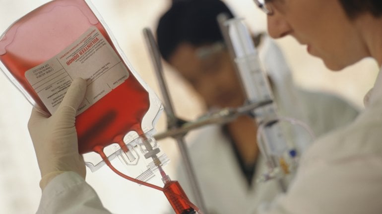 Eine Ärztin entnimmt Blut aus einem Transfusionsbeutel.