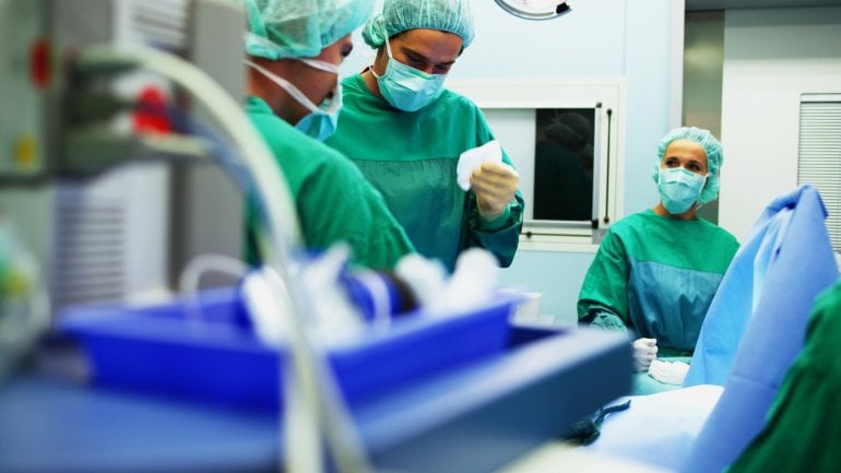Das Bild zeigt mehrere Chirurgen bei einer Operation.