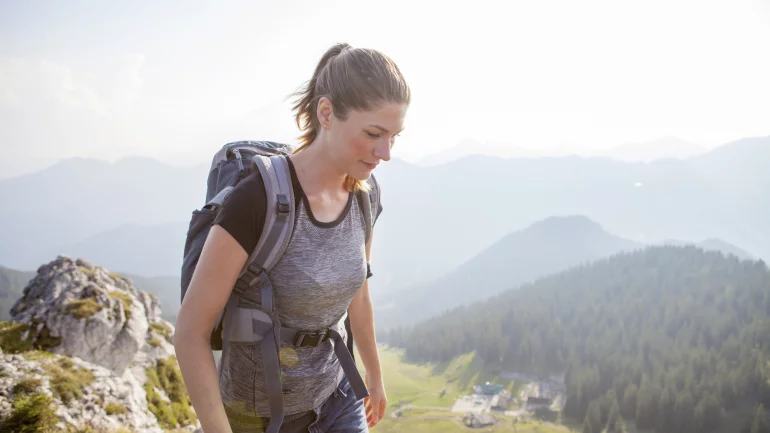 Eine junge Frau beim Wandern in den Bergen.