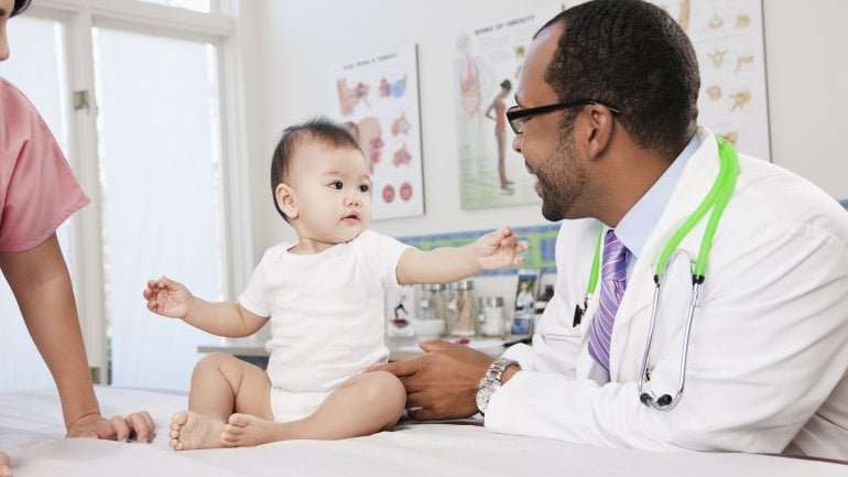 Sinnbild für einen Hodenhochstand: Säugling wird von einem Arzt untersucht.
