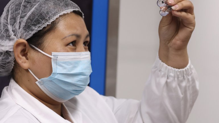 Eine chinesische Forscherin hält eine Ampulle Sinovac Impfstoff hoch