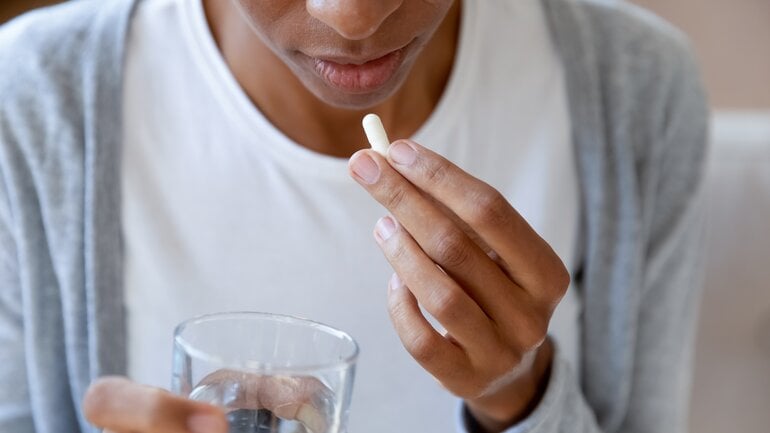 Eine Frau ist im Begriff, eine Schmerztablette zu nehmen