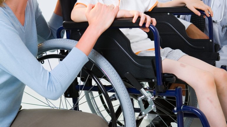 Das Bild zeigt ein Kind in einem Rollstuhl.