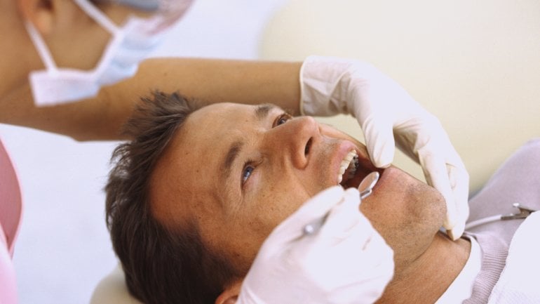 Das Bild zeigt einen Mann beim Zahnarzt.