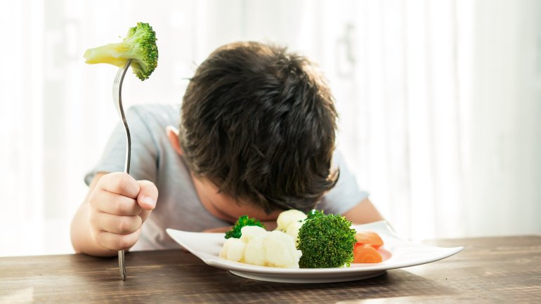 Ein Junge mag sein Gemüse nicht essen.