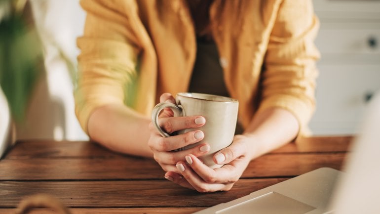Koffeinentzug: Person hält eine Tasse Kaffee in der Hand