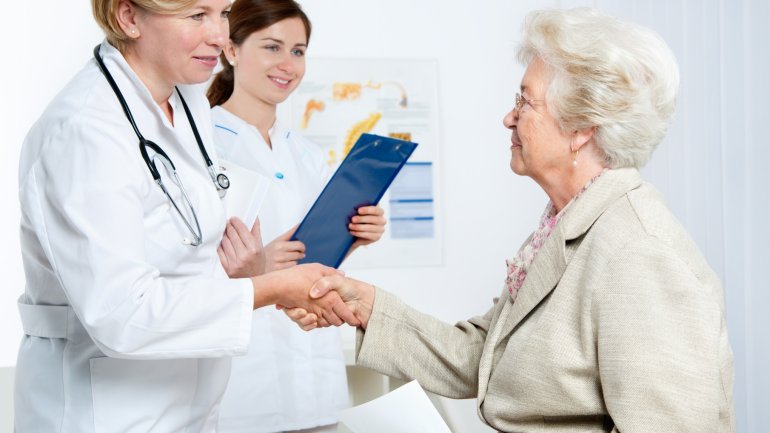 Eine Ärztin begrüßt eine ältere Patientin in der Praxis.
