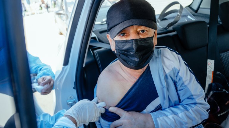 Ein Mann aus Peru wird im Auto gegen Corona geimpft