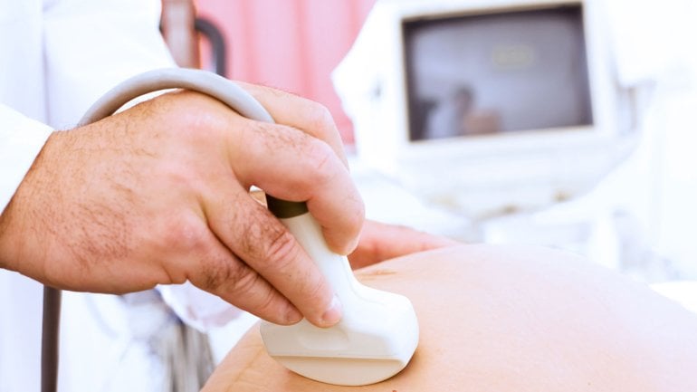 Man sieht eine schwangere Frau bei einer Ultraschalluntersuchung.
