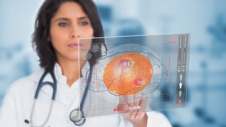 Eine Ärztin studiert eine Tafel, auf der ein Gehirn abgebildet ist.