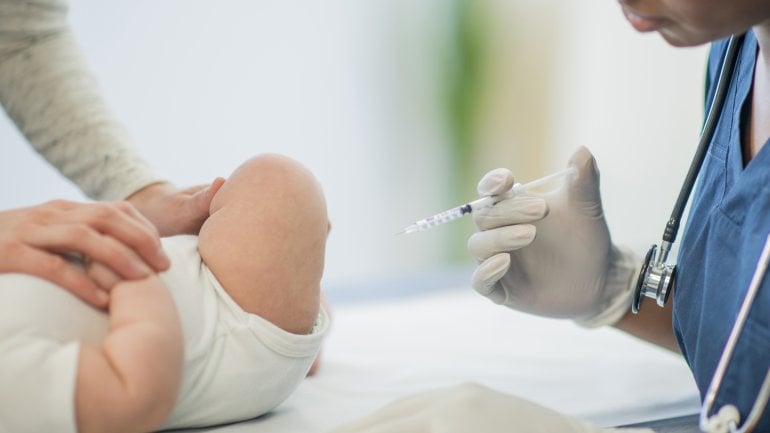 Ein Baby bekommt eine Impfung in den Oberschenkel.