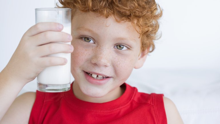 Das Bild zeigt einen Jungen mit Milchglas.