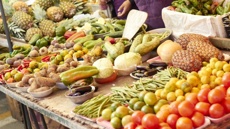 Das Bild zeigt einen Marktstand mit Obst und Gemüse.