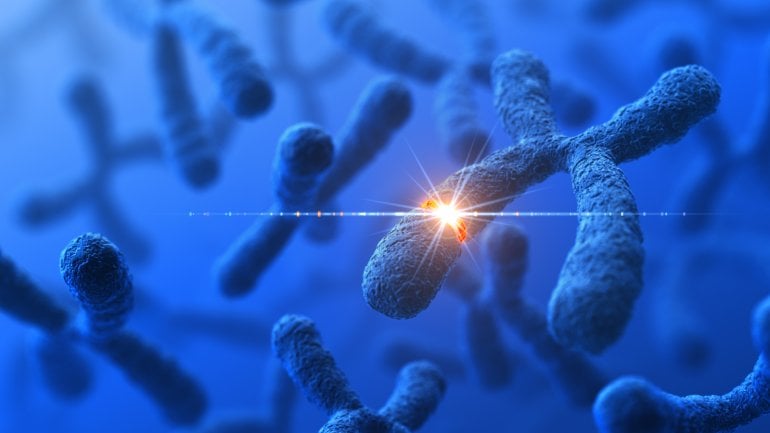 Man sieht stilisierte Chromosomen mit einer durch einen leuchtenden Punkt dargestellten genetischen Veränderung.