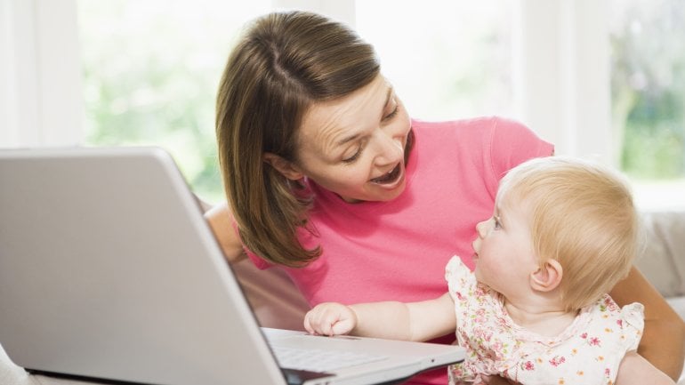 Das Bild zeigt eine Frau und ein Baby am Laptop.