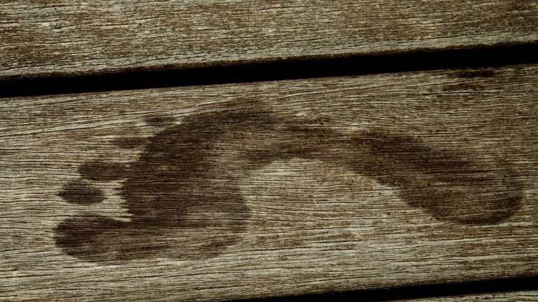 Nasser Fußabdruck auf einer Holzdiele