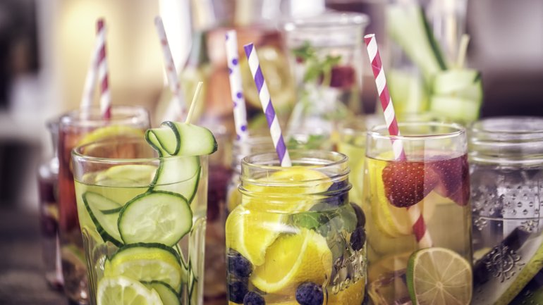 Verschiedene Gläser mit Wasser und unterschiedlichen Früchten.