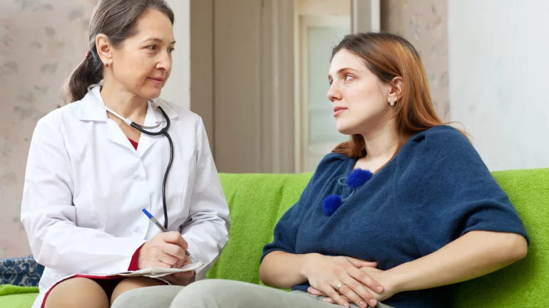 Frau mit Flankenschmerzen spricht mit Ärztin.