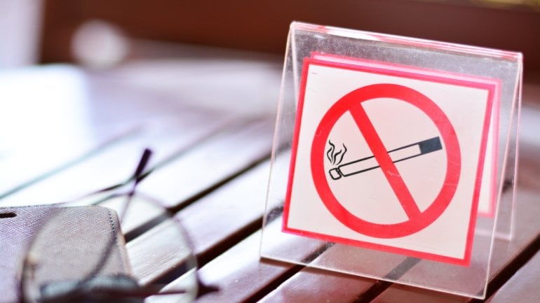 Ein Schild mit einer durchgestrichenen Zigarette, das auf einem Tisch steht.